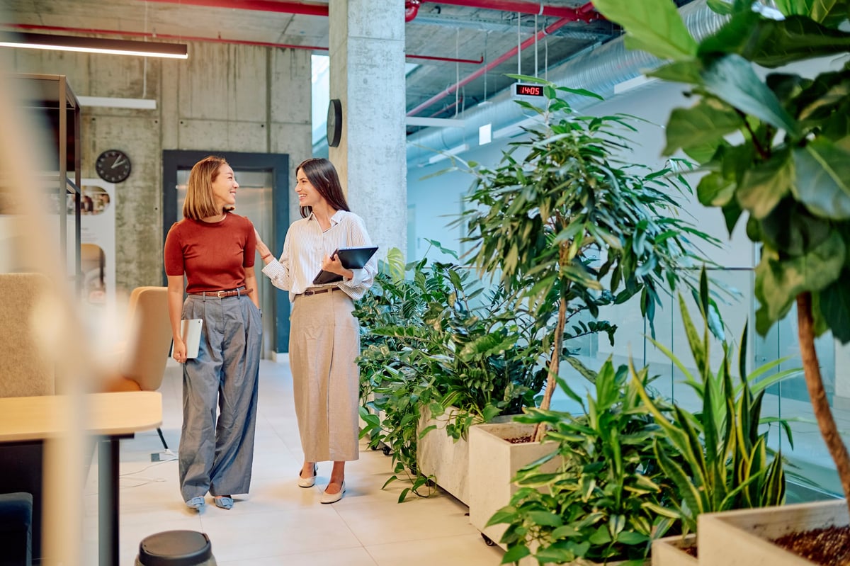 Two businesswomen walking through a vibrant green office